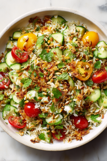 Salade de riz croustillante avec légumes frais et herbes aromatiques, parfaite pour les repas d'été et d'automne, rapide à préparer.