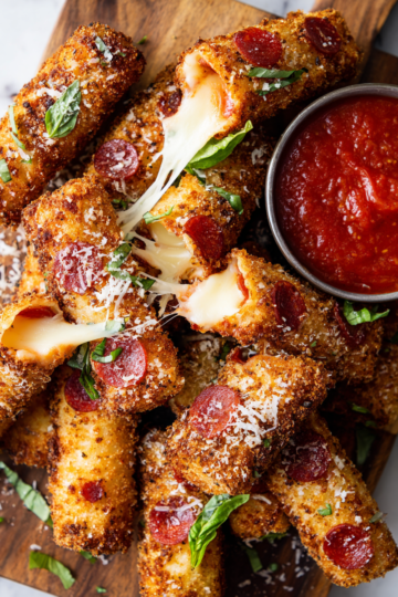 Savoureux Bâtonnets de Mozzarella au Pepperoni Bâtonnets croustillants de mozzarella au pepperoni, servis avec sauce marinara, parfaits pour un apéritif convivial.