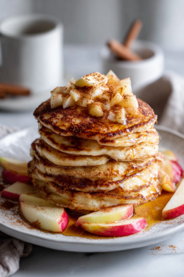 Savourez des Pancakes Moelleux d'Automne Pancakes moelleux d'automne sur une assiette avec des fruits et du sirop d'érable